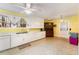 Bright kitchen featuring white cabinetry, vintage flooring, and ample counter space at 413 S Maple St, Graham, NC 27253