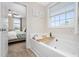 This bathroom features a large soaking tub and a view into the main bedroom at 50 Yelverton Ct, Holly Springs, NC 27540