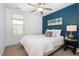 This bedroom offers a stylish accent wall, ceiling fan, and bright natural light at 50 Yelverton Ct, Holly Springs, NC 27540