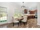 Light-filled dining area showcasing hardwood floors, modern lighting, and elegant furnishings at 50 Yelverton Ct, Holly Springs, NC 27540