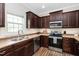 Well-equipped kitchen with stainless steel appliances and dark wood cabinets at 50 Yelverton Ct, Holly Springs, NC 27540
