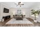 Bright living room featuring hardwood floors, a ceiling fan, neutral walls, and elegant furnishings at 50 Yelverton Ct, Holly Springs, NC 27540