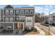 Gray townhome with stone accents, manicured landscaping, a private entrance, and visible street parking at 5200 Invention Way, Raleigh, NC 27616