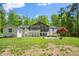 Large backyard featuring a patio, mature trees, lush greenery, and architectural details of the home's rear facade at 5313 Edington Ln, Raleigh, NC 27604