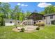 Beautiful backyard featuring a stone patio, lush greenery, and a rear view of the home's architectural details at 5313 Edington Ln, Raleigh, NC 27604