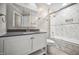 Modern bathroom featuring a shower over bath, sleek vanity and stylish marble tile at 5313 Edington Ln, Raleigh, NC 27604