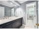 Bathroom featuring a double vanity with marble countertops, a large mirror and a tile shower at 5313 Edington Ln, Raleigh, NC 27604