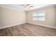 Bright bedroom featuring a ceiling fan, neutral walls, laminate flooring, and a large window at 5313 Edington Ln, Raleigh, NC 27604