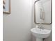 Stylish half bathroom with a sleek pedestal sink, mirror, and modern decor at 5340 Big Bass Dr, Raleigh, NC 27610