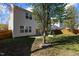 A home's backyard features a patio, lawn, and a mature tree providing shade at 5405 Seaspray Ln, Raleigh, NC 27610
