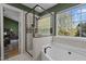 A luxurious primary bathroom showcases a glass shower and a soaking tub near a sunlit window at 5405 Seaspray Ln, Raleigh, NC 27610