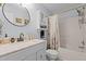 Bright bathroom featuring a vanity with a granite countertop, a shower and tub combination, and a large mirror at 5405 Seaspray Ln, Raleigh, NC 27610