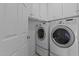 Convenient laundry room with modern washer and dryer, built-in cabinets, and tiled flooring at 5405 Seaspray Ln, Raleigh, NC 27610