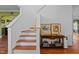 Elegant staircase featuring wood steps, white risers, and a classic banister with decor at 5405 Seaspray Ln, Raleigh, NC 27610