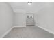 Neutral bedroom featuring a single window, neutral carpet and a white baseboard at 5450 Hunter Hill Rd, Rocky Mount, NC 27804