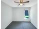 A bright bedroom with new carpet, a ceiling fan, and a window looking out onto the front yard at 610 Shepard School Rd, Zebulon, NC 27597