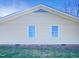 Exterior featuring a brick and yellow siding with a roof and two windows at 610 Shepard School Rd, Zebulon, NC 27597