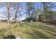 Large backyard featuring a treehouse, mature trees, and a storage shed on a sunny day at 63 Halter Ct, Angier, NC 27501