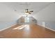 Large bonus room featuring laminate flooring, multiple ceiling fans, and built-in shelving at 63 Halter Ct, Angier, NC 27501
