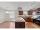 Open kitchen with wood cabinets, stainless appliances, and breakfast bar area at 63 Halter Ct, Angier, NC 27501