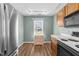 Eat-in kitchen with wood cabinets, white countertops, stainless steel refrigerator, and window with a street view at 6817 Fairpoint Ct, Raleigh, NC 27613