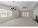 Spacious living room featuring neutral carpet, large windows, and a traditional chandelier at 6817 Fairpoint Ct, Raleigh, NC 27613