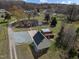 Aerial view of a home with detached garage, open land, and surrounding greenery at 71 Romans Rd, Roxboro, NC 27574