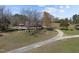 Aerial view of a home with large grounds and a gravel driveway surrounded by mature trees at 71 Romans Rd, Roxboro, NC 27574