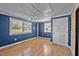 Bright bedroom with blue walls, hardwood floors, and natural light from three windows at 71 Romans Rd, Roxboro, NC 27574