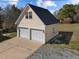 Exterior view of a two-car garage with an overhead loft featuring a charming exterior and ample parking at 71 Romans Rd, Roxboro, NC 27574