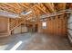 Unfinished garage featuring exposed wood beams, stairs to upper level, and a workbench area at 71 Romans Rd, Roxboro, NC 27574