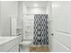 Bathroom featuring a shower-tub combo with decorative curtain, vanity, toilet and linen closet at 909 Sea Holly Dr, Zebulon, NC 27597