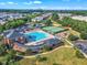 Stunning aerial view of the community pool, clubhouse, tennis courts, and playground nestled within lush green landscaping at 946 Consortium Dr, Raleigh, NC 27603