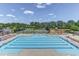 Beautiful swimming pool with lane lines and lounge chairs surrounded by lush greenery and a tennis court at 946 Consortium Dr, Raleigh, NC 27603