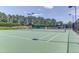 Well-maintained tennis court featuring professional lighting and fencing surrounded by lush trees at 946 Consortium Dr, Raleigh, NC 27603