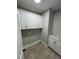 Spacious laundry room with storage cabinets, marble countertop and neutral paint color at Lot 14H Good Shepherd Trl, Spring Hope, NC 27882