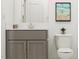 Bright bathroom with a gray vanity, modern fixtures, and contemporary artwork enhancing the space at 1004 Red Roses Ave, Durham, NC 27703