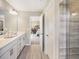 Bright bathroom showcasing double vanity, modern fixtures, and open doorway to bedroom at 1005 Red Roses Ave, Durham, NC 27703