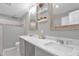 Light-filled bathroom with double sinks, vanity, mirrors, and a tiled shower at 1022 Glover Rd, Dunn, NC 28334