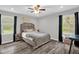 Comfortable bedroom with two windows, neutral decor, updated flooring, and a ceiling fan at 1022 Glover Rd, Dunn, NC 28334