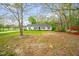 Quaint single-story home nestled on a lush lot with mature trees and vibrant azaleas at 1022 Glover Rd, Dunn, NC 28334