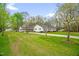 Attractive single-story home with an attached carport on an expansive lawn with mature trees at 1022 Glover Rd, Dunn, NC 28334