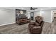 Comfortable living room offers a brick fireplace, ceiling fan, and updated flooring at 1022 Glover Rd, Dunn, NC 28334