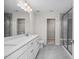 Bathroom featuring a double vanity with framed mirrors, a full walk-in shower, and doorway to walk-in closet at 104 Fairwinds Dr, Lillington, NC 27546