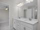 Bathroom featuring a double vanity with framed mirrors, a full walk-in shower, and doorway to main bedroom at 104 Fairwinds Dr, Lillington, NC 27546
