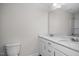 Modern bathroom featuring a white vanity with double sinks, a toilet, and a shower with a glass door at 104 Fairwinds Dr, Lillington, NC 27546