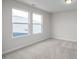 Bright bedroom featuring neutral carpet, fresh paint, and an abundance of natural light from the double windows at 104 Fairwinds Dr, Lillington, NC 27546