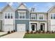Charming two-story townhome featuring a one car garage, well-maintained lawn, and neutral color siding at 104 Ripple Way # 318, Clayton, NC 27520