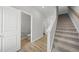 Bright hallway featuring a staircase, wood-look flooring, a half bathroom, and white trim throughout at 104 Ripple Way # 318, Clayton, NC 27520