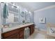 Well-lit bathroom featuring double sinks, granite counters, and separate tub and toilet areas at 10400 Rosegate Ct # 3, Raleigh, NC 27617